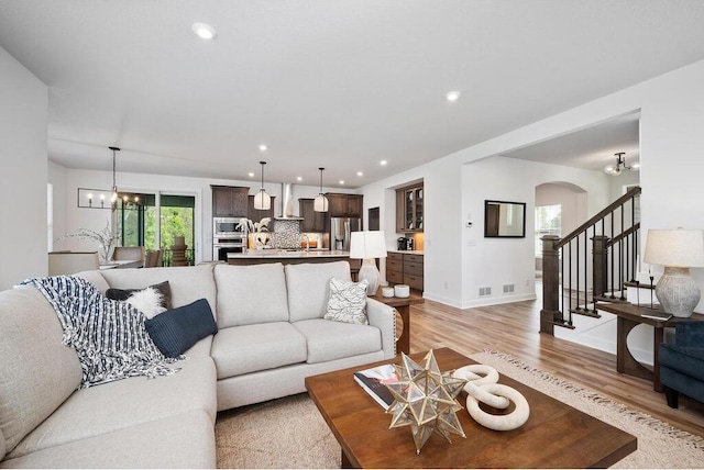 living room with light hardwood / wood-style flooring and a chandelier