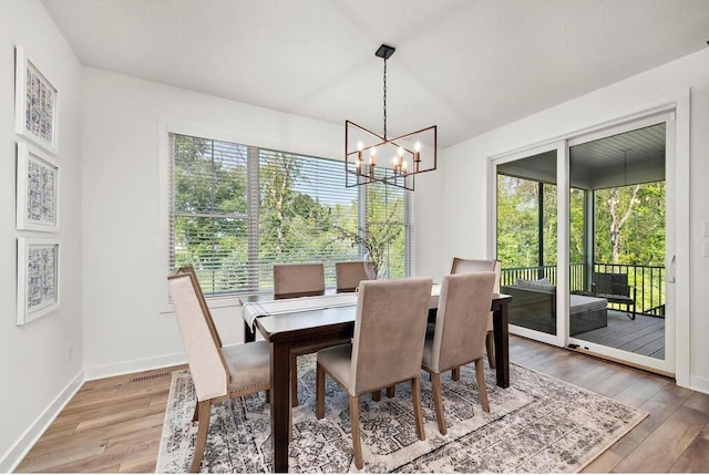 dining area with an inviting chandelier and light hardwood / wood-style flooring