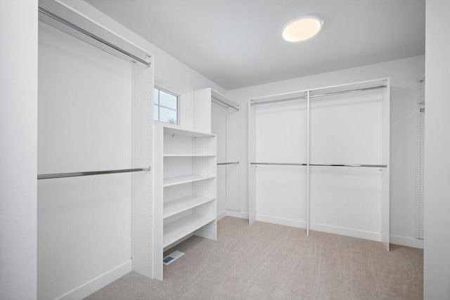 walk in closet featuring light colored carpet