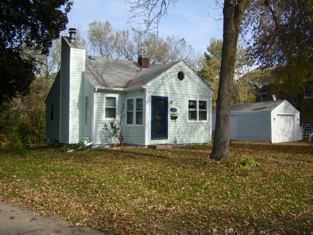 view of front of home featuring an outdoor structure, a front yard, and a garage