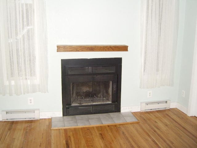 interior details with baseboard heating and light hardwood / wood-style flooring