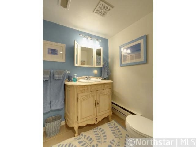 bathroom with vanity, baseboard heating, and toilet