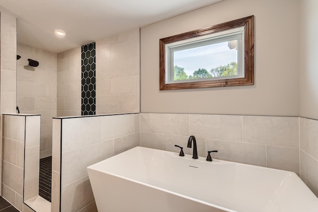 bathroom with tile walls and separate shower and tub