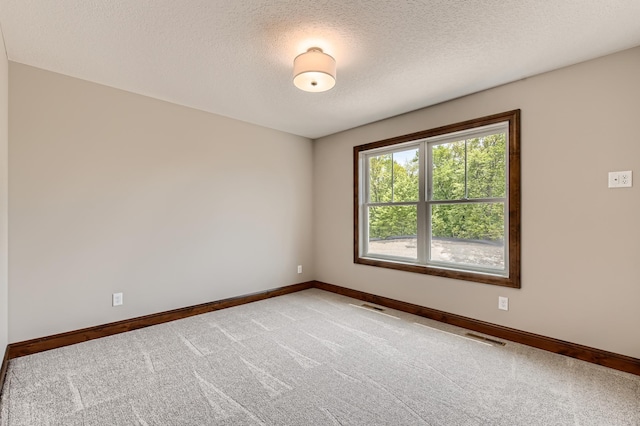 unfurnished room featuring a textured ceiling and carpet