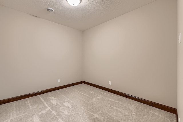 carpeted spare room featuring a textured ceiling