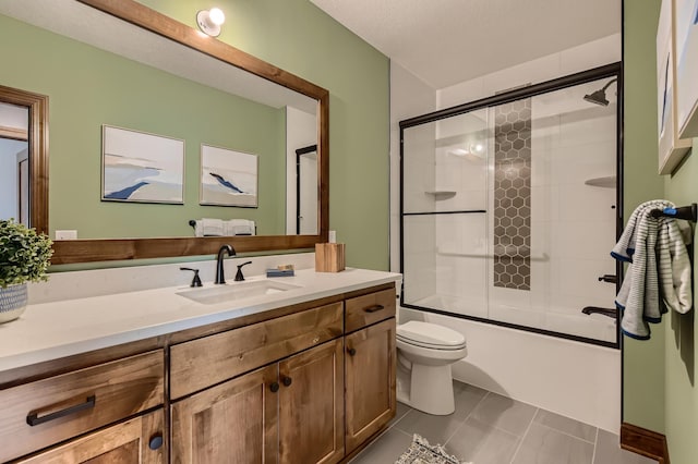 full bathroom featuring toilet, enclosed tub / shower combo, a textured ceiling, tile patterned floors, and vanity