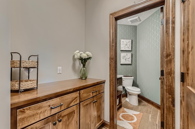 bathroom with wood-type flooring, toilet, and vanity