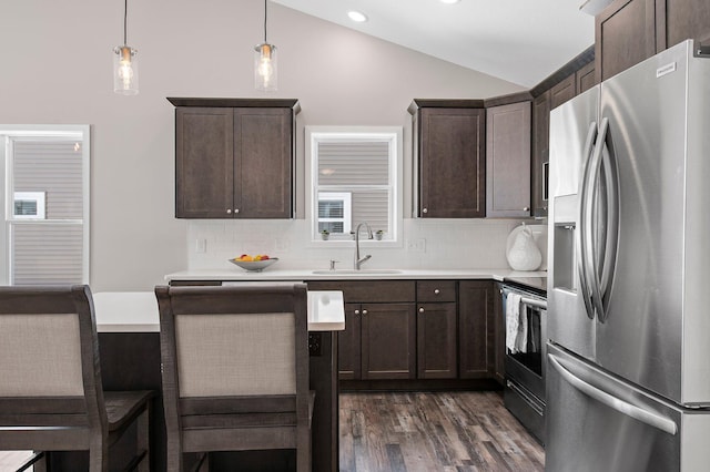 kitchen with lofted ceiling, backsplash, sink, hanging light fixtures, and stainless steel appliances