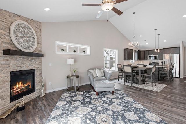 living room featuring high vaulted ceiling, ceiling fan, dark wood-type flooring, and a fireplace