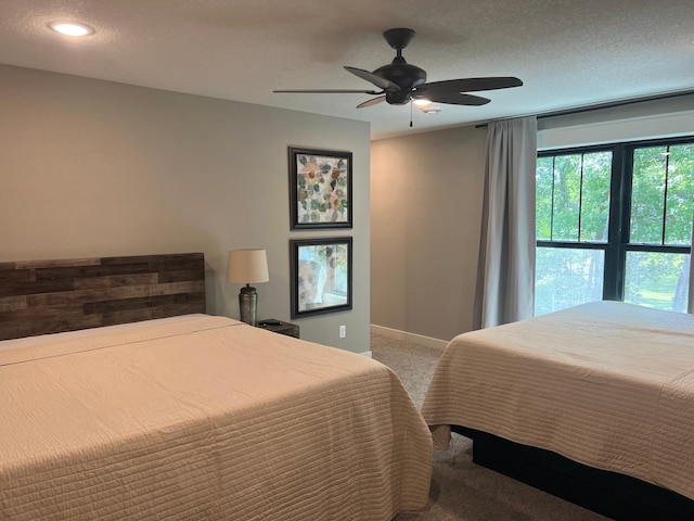 bedroom featuring ceiling fan, a textured ceiling, and carpet flooring