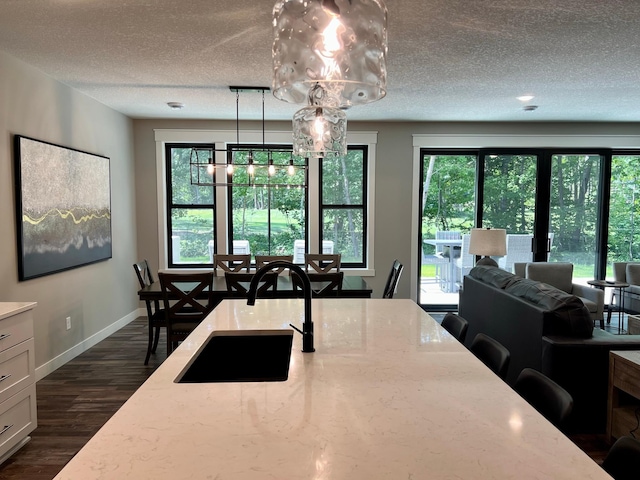 dining space featuring a textured ceiling, a wealth of natural light, and dark hardwood / wood-style flooring