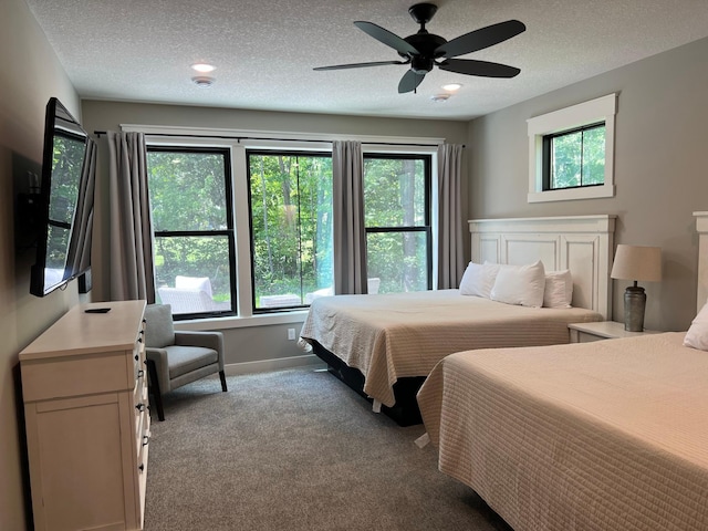 bedroom with light carpet, a textured ceiling, ceiling fan, and multiple windows