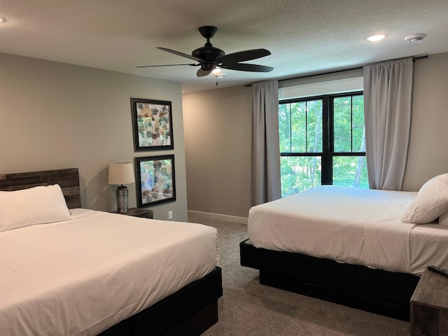 bedroom with carpet flooring, ceiling fan, and a textured ceiling