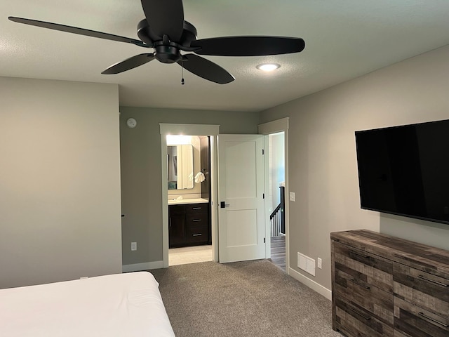 bedroom featuring ceiling fan, connected bathroom, and light carpet