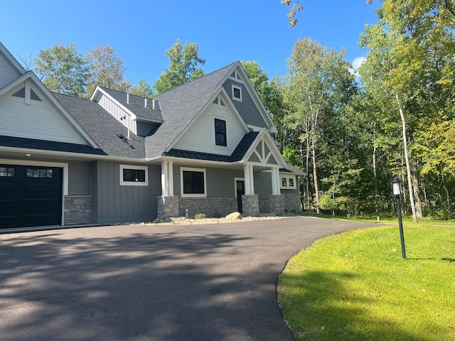 craftsman house with a front lawn and a garage