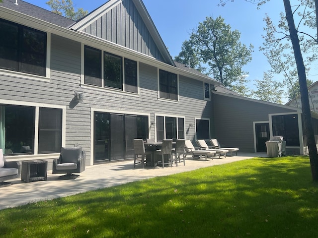 back of property with a yard and a patio