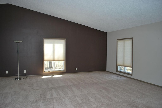 carpeted spare room featuring lofted ceiling