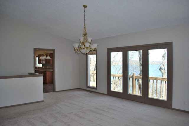 unfurnished dining area with light carpet, a healthy amount of sunlight, and a chandelier