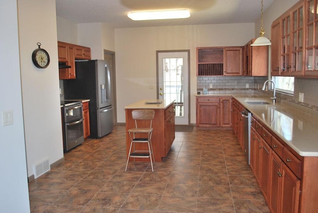 kitchen with a kitchen bar, a healthy amount of sunlight, sink, and stainless steel appliances