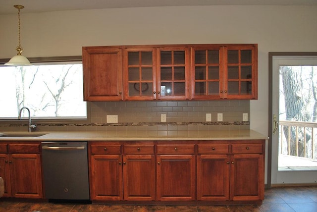 kitchen featuring stainless steel dishwasher, sink, tasteful backsplash, and pendant lighting