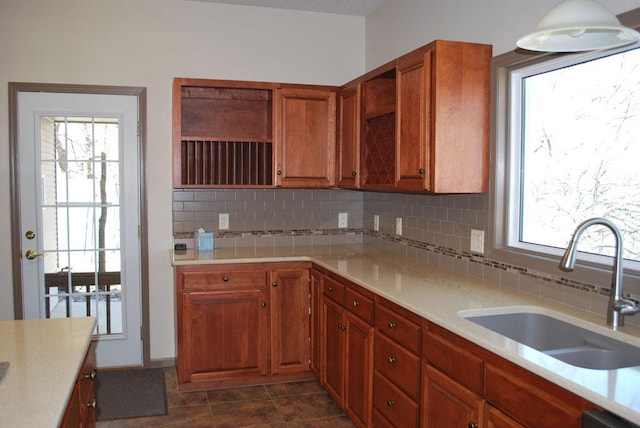 kitchen featuring backsplash, dark tile flooring, and sink