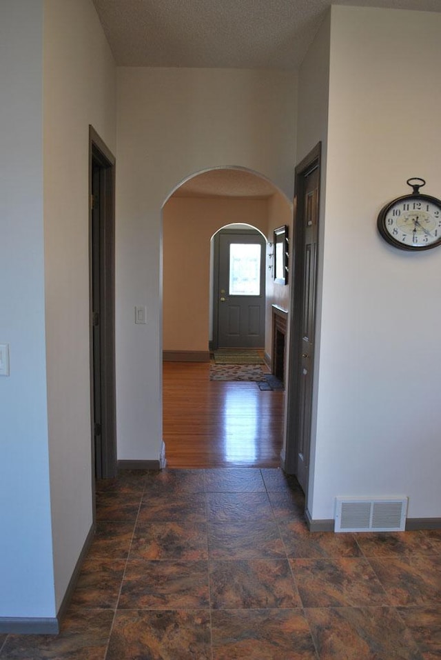 hallway with dark hardwood / wood-style floors and a textured ceiling