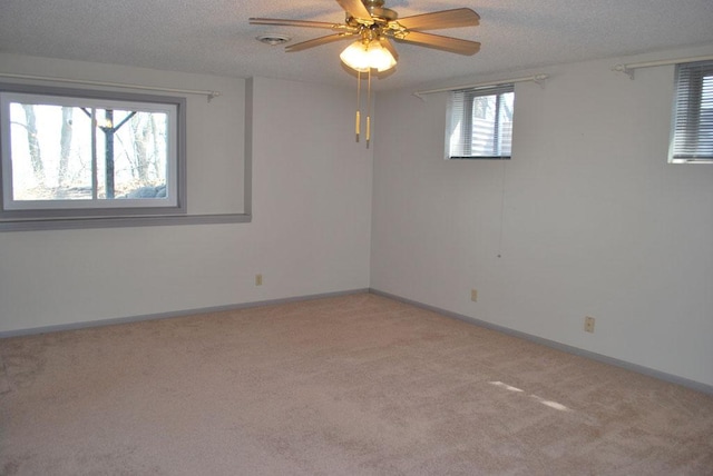 carpeted empty room featuring ceiling fan and a textured ceiling