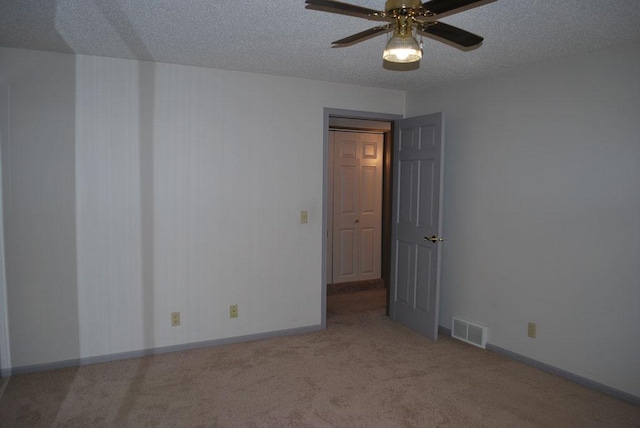 carpeted empty room with a textured ceiling and ceiling fan