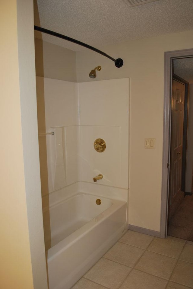 bathroom featuring a textured ceiling, tile floors, and shower / tub combination