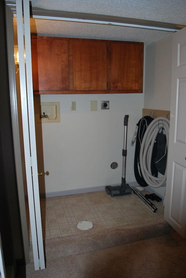 washroom with cabinets, a textured ceiling, carpet, and hookup for a washing machine