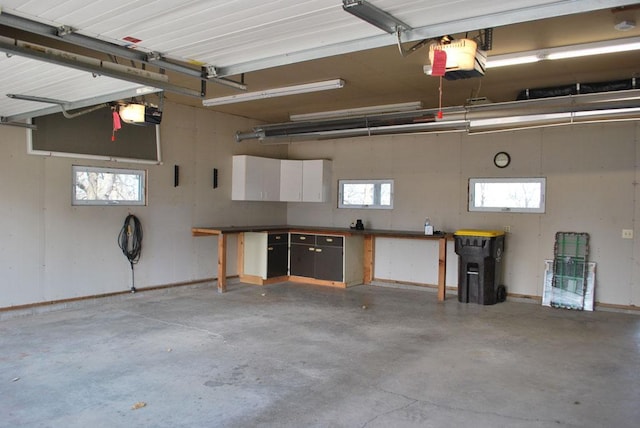 garage with a garage door opener and a workshop area