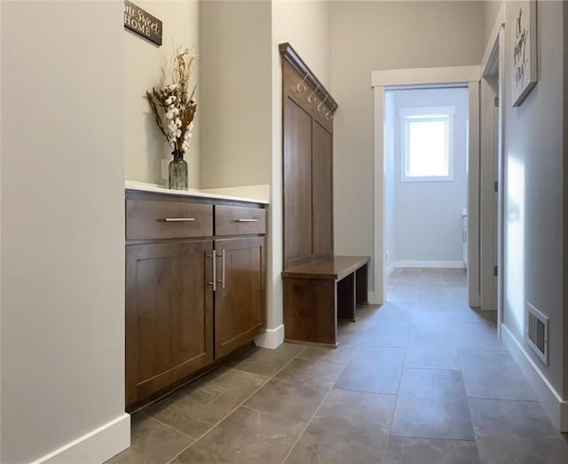 mudroom with light tile patterned floors, visible vents, and baseboards