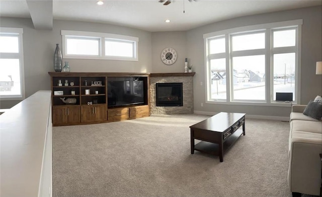 living area featuring light carpet, baseboards, a glass covered fireplace, and recessed lighting