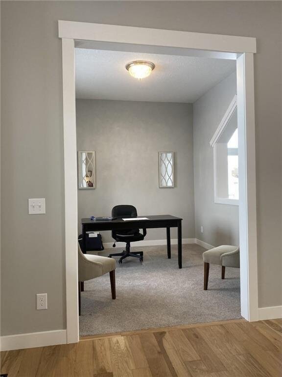 office area with baseboards and wood finished floors