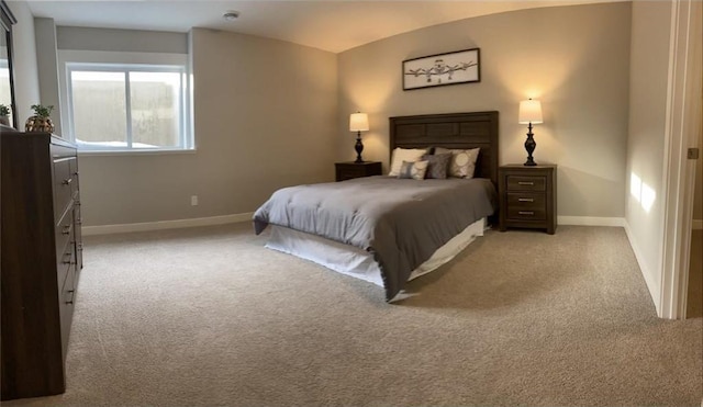 bedroom with lofted ceiling, light colored carpet, and baseboards