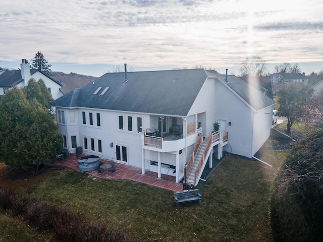 rear view of house featuring a lawn, a patio area, and a balcony