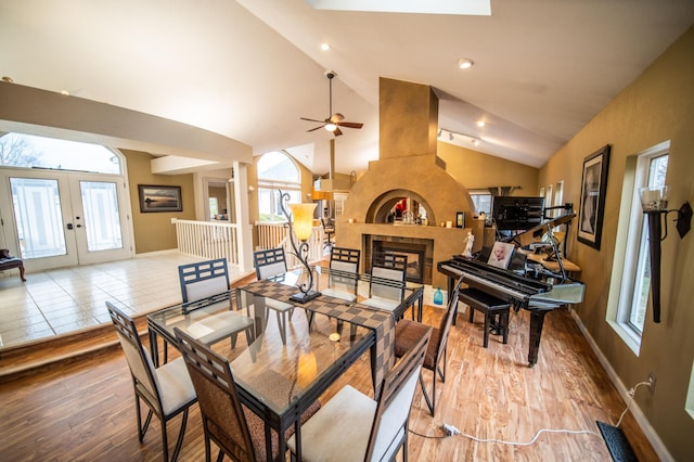 dining space with ceiling fan, light hardwood / wood-style floors, lofted ceiling, and french doors