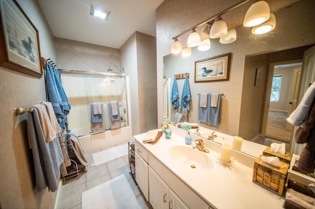 bathroom with tile patterned floors, shower / bath combination with glass door, and vanity