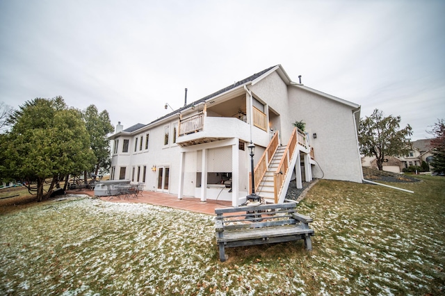 back of house featuring a balcony and a yard