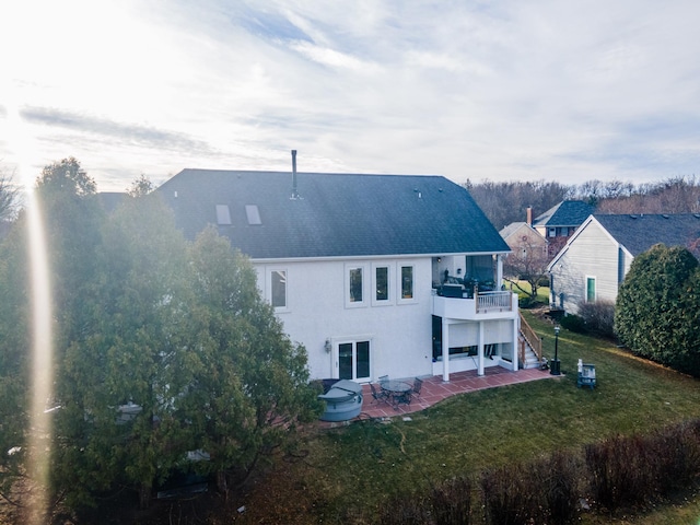 back of house with a yard, a balcony, and a patio area