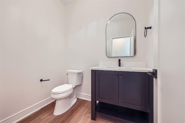 bathroom with hardwood / wood-style floors, vanity, and toilet