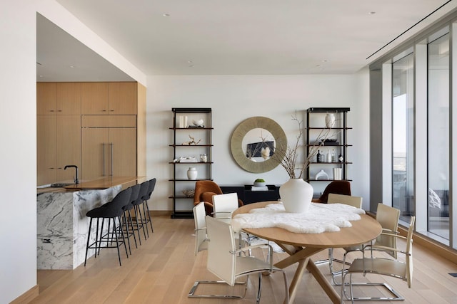 dining space featuring sink and light hardwood / wood-style floors