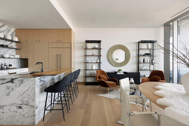 kitchen with light hardwood / wood-style flooring, paneled built in fridge, sink, and light brown cabinetry