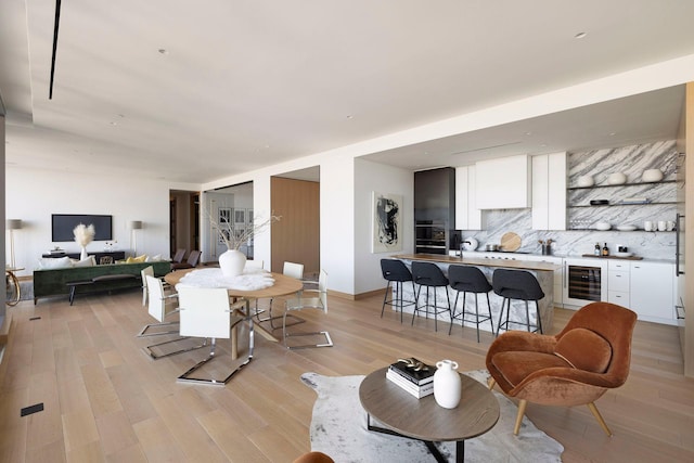 living room featuring wine cooler and light wood-type flooring