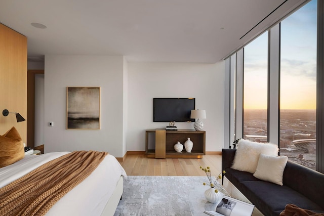 bedroom featuring light hardwood / wood-style flooring, multiple windows, and expansive windows