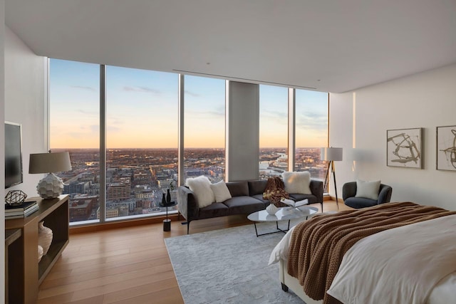 bedroom featuring light hardwood / wood-style flooring, multiple windows, and a wall of windows