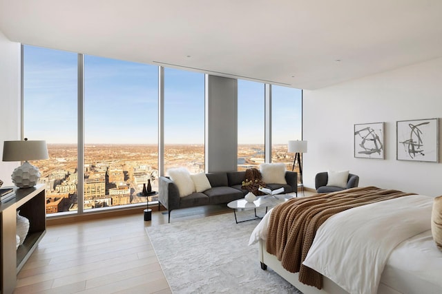 bedroom with light hardwood / wood-style floors and floor to ceiling windows