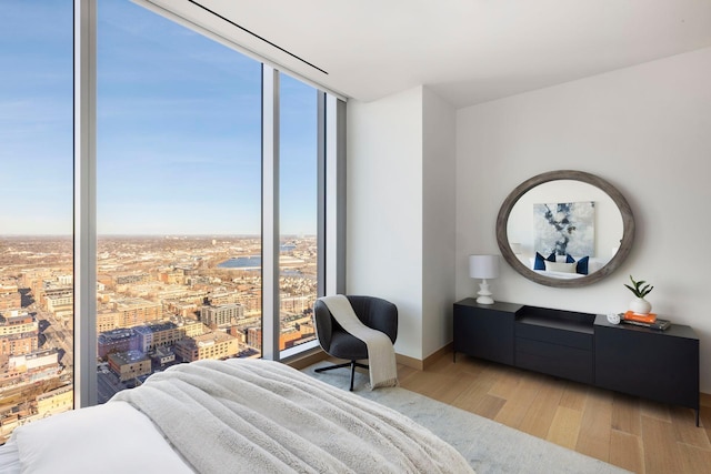 bedroom with light hardwood / wood-style floors and a wall of windows