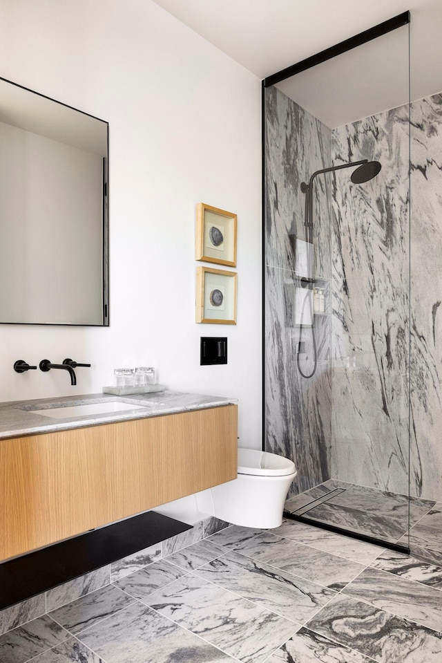 bathroom with vanity, tiled shower, and toilet