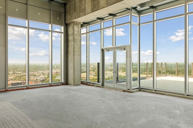 spare room featuring concrete flooring and a high ceiling